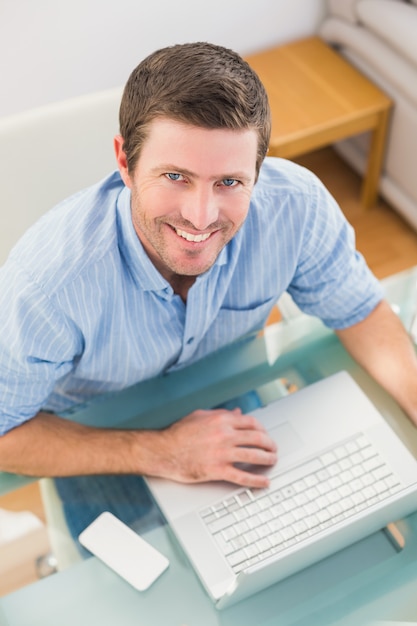 Sonriente hombre de negocios usando su computadora portátil en el escritorio