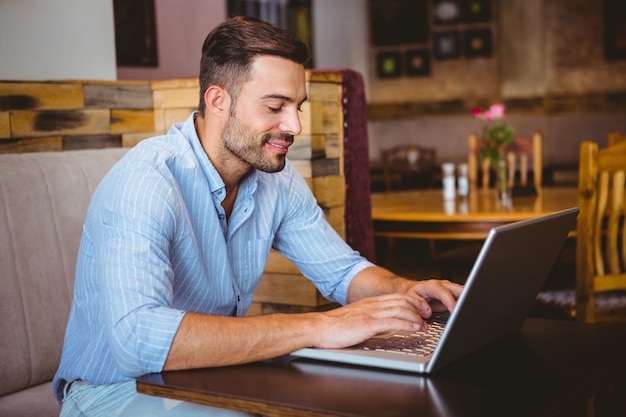 Sonriente hombre de negocios usando su computadora portátil