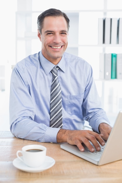 Sonriente hombre de negocios usando su computadora