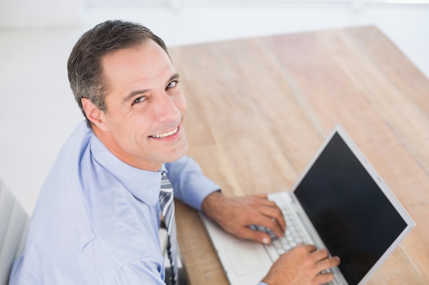 Sonriente hombre de negocios usando su computadora