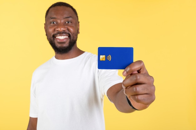 Sonriente Hombre Negro Mostrando Tarjeta Crédito Publicidad Banco Fondo Amarillo