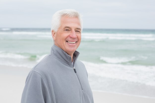 Sonriente hombre senior casual en la playa