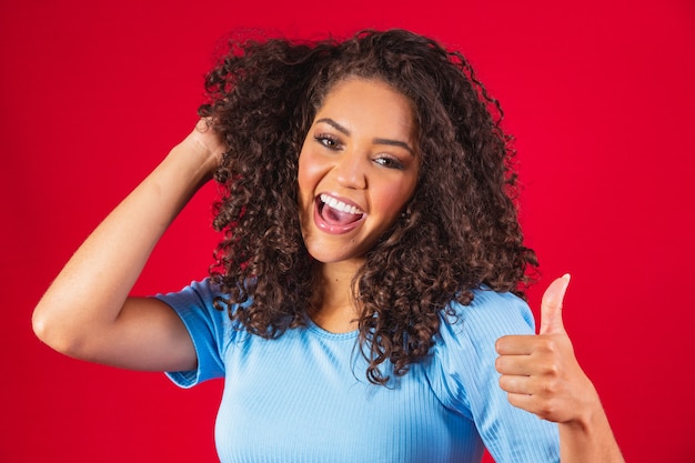 Sonriente joven afro haciendo el signo de ok.