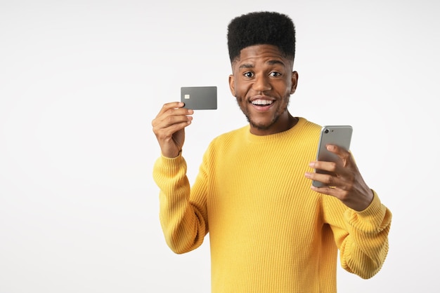 Sonriente joven afroamericano en pose casual aislado sobre fondo de pared blanca