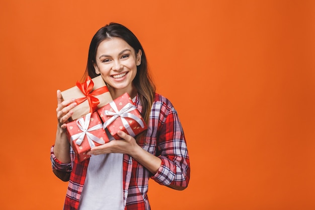 Sonriente joven bella mujer tiene caja de regalo roja