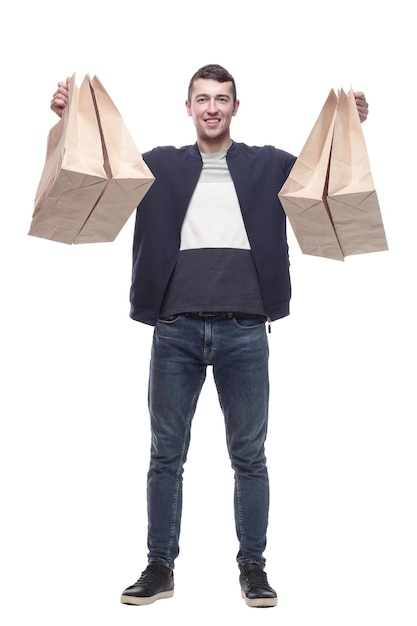 Sonriente joven con bolsas de compras aislado en un blanco