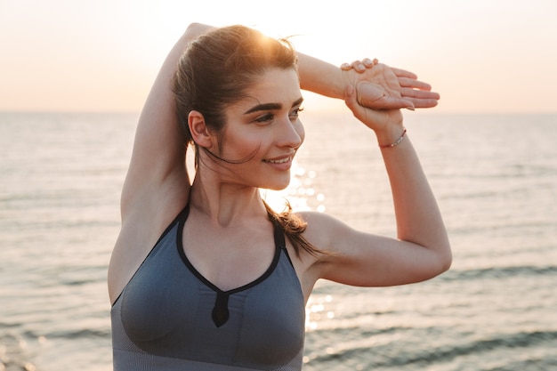 Sonriente joven deportista haciendo ejercicios de estiramiento