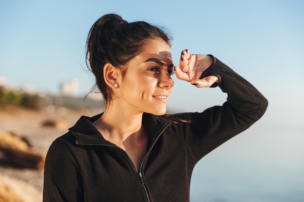 Sonriente joven deportista en la playa