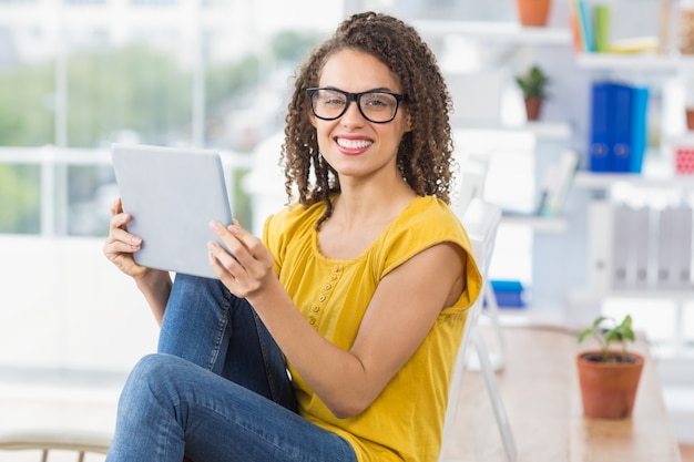 Sonriente joven empresaria sosteniendo una tableta