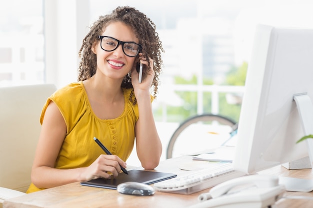 Sonriente joven empresaria en el teléfono