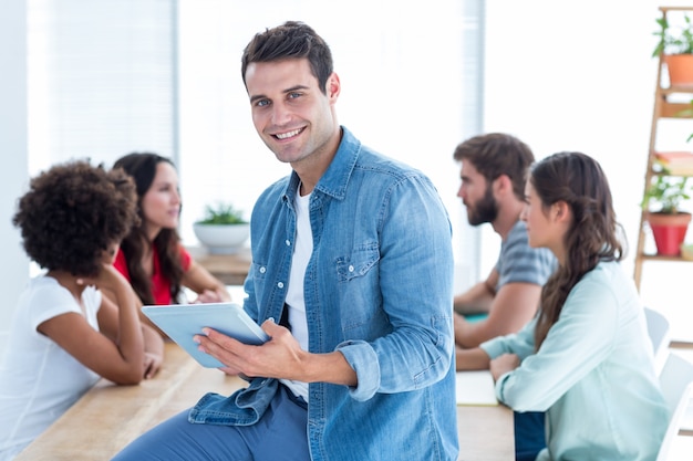 Sonriente joven empresario usando una tableta