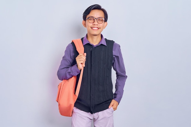 Sonriente joven estudiante universitario asiático en ropa casual mochila aislada sobre fondo gris Educación en el concepto de colegio universitario de secundaria