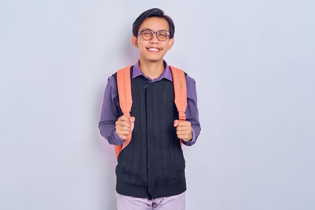 Sonriente joven estudiante universitario asiático en ropa casual mochila aislada sobre fondo gris Educación en el concepto de colegio universitario de secundaria