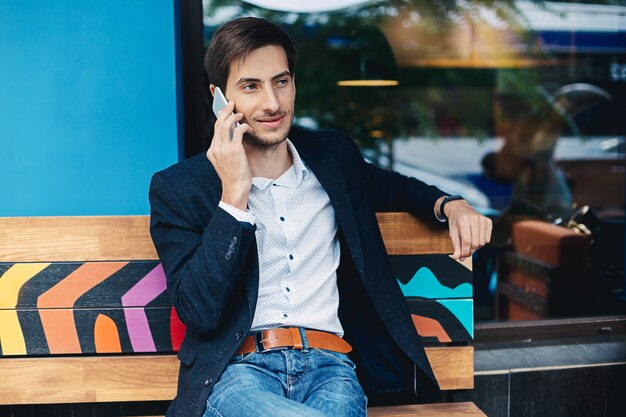 Sonriente joven hablando por teléfono móvil