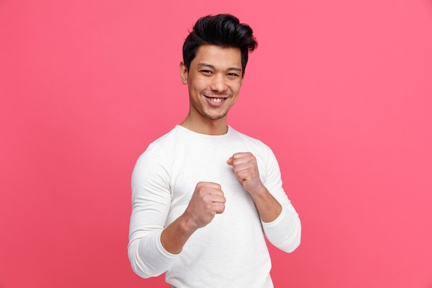 Sonriente joven haciendo gesto de boxeo