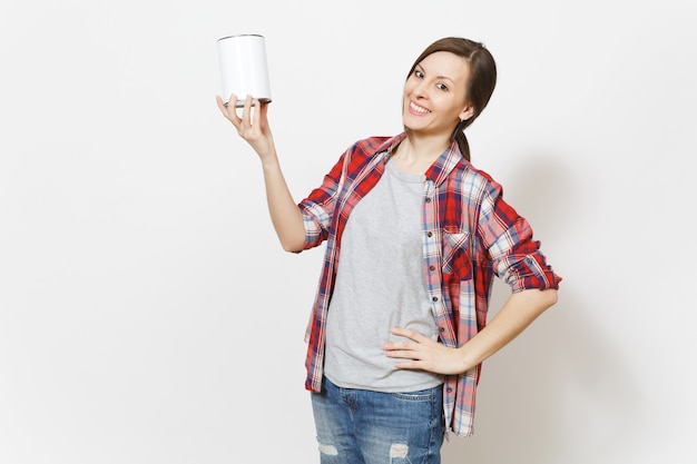 Sonriente joven hermosa mujer en ropa casual sosteniendo lata de pintura vacía con espacio de copia aislado sobre fondo blanco. Instrumentos, accesorios para habitación de apartamento de renovación. Reparar el concepto de hogar.