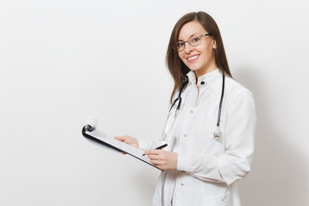 Sonriente joven médico confía en mujer con estetoscopio, gafas aisladas sobre fondo blanco. Doctora en bata médica con tarjeta sanitaria en la carpeta del bloc de notas. Concepto de medicina del personal sanitario.