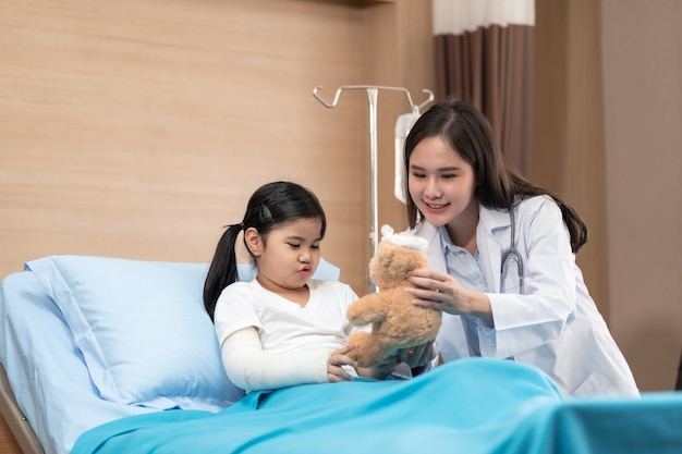 Sonriente joven médico pediatra y paciente infantil