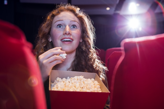 Sonriente joven mirando una película