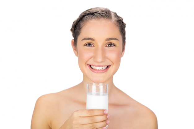 Sonriente joven modelo con vaso de leche