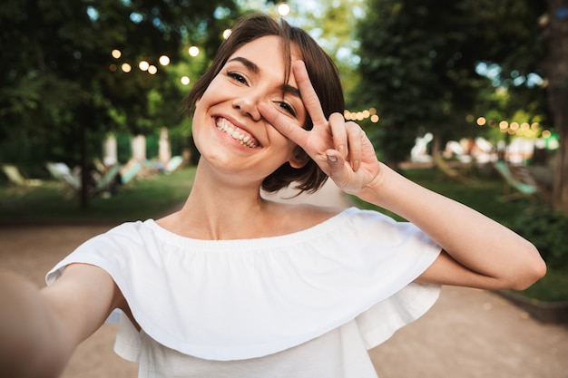 Foto sonriente joven mostrando gesto de paz