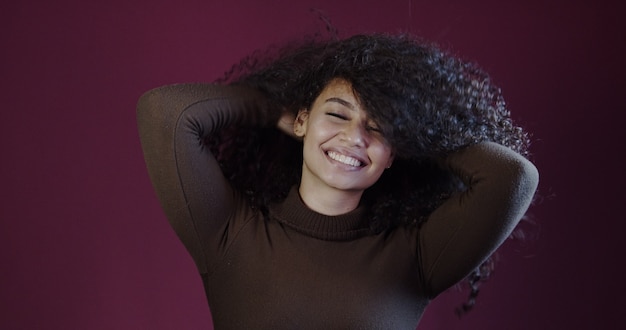 Sonriente joven mujer afro latina. Alegría, positivo y amor. Hermoso cabello estilo africano