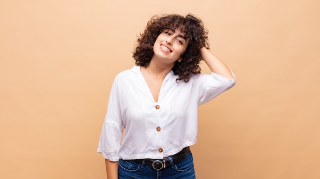 Sonriente joven mujer bonita con pelo rizado