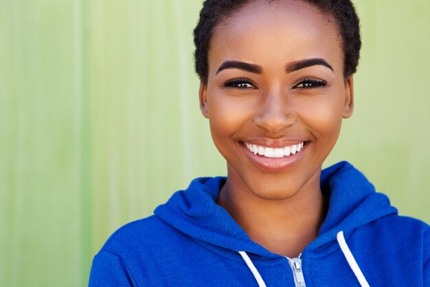 Sonriente joven mujer negra sobre fondo verde