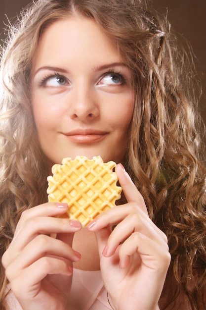 Sonriente joven mujer rubia con un pastel