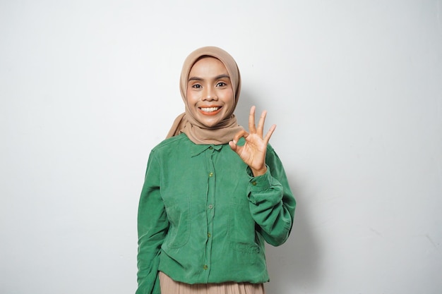 Sonriente joven musulmana asiática vestida con un gesto informal de estar bien