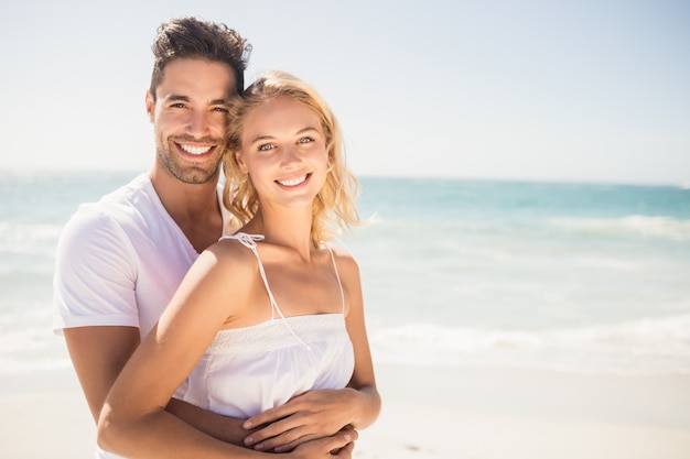 Sonriente joven pareja abrazándose