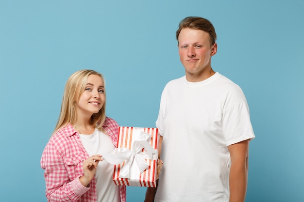 Sonriente joven pareja dos amigos chico y mujer en camisetas rosas blancas posando