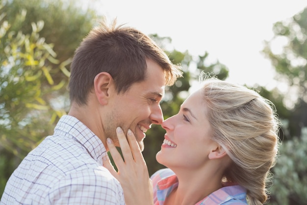 Sonriente joven pareja mirando el uno al otro en el parque