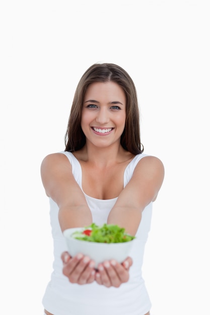 Sonriente joven sosteniendo una ensalada