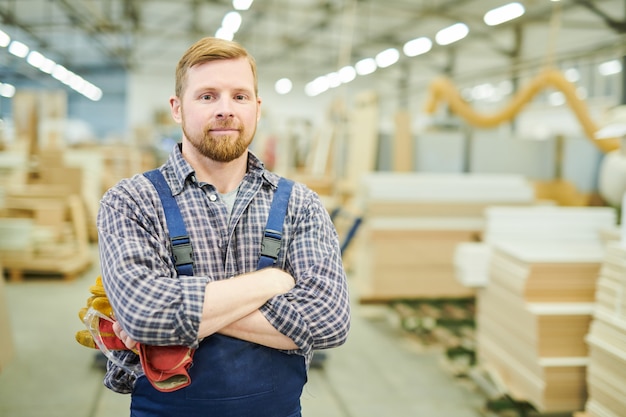 Sonriente joven trabajador en la fábrica de muebles