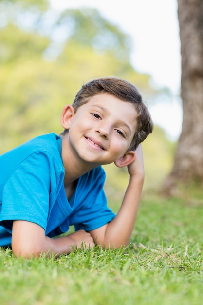 Sonriente joven tumbado en la hierba