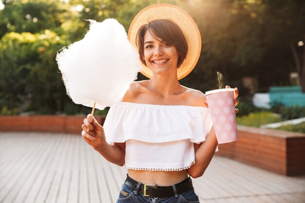 Sonriente joven vestida con ropa de verano comiendo