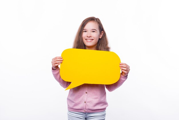 Sonriente a linda joven sosteniendo el bocadillo de diálogo amarillo