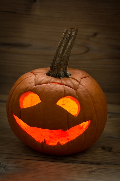 Sonriente linterna de calabaza en un fondo de madera