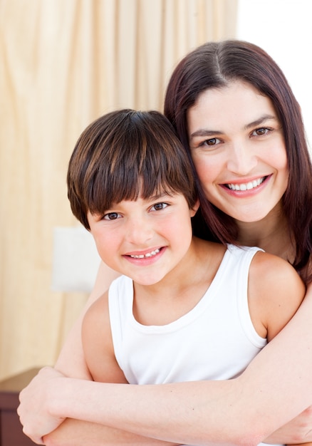 Foto sonriente madre abrazando a su hijo