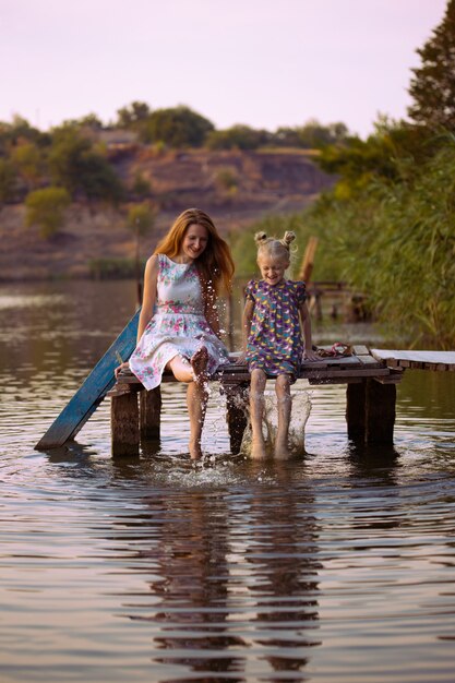 Foto sonriente, madre e hija, sentado, en, muelle