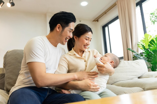 Sonriente madre y padre con hijo recién nacido en casa