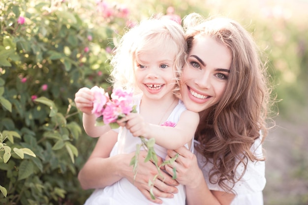 Sonriente, madre, tenencia, niño, niña, en, campo rosa