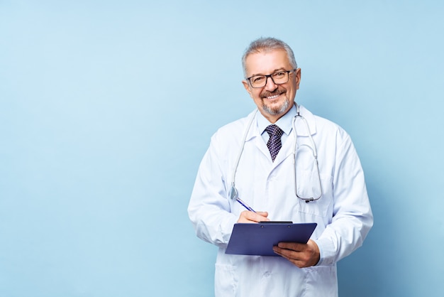 Sonriente médico senior con un estetoscopio.