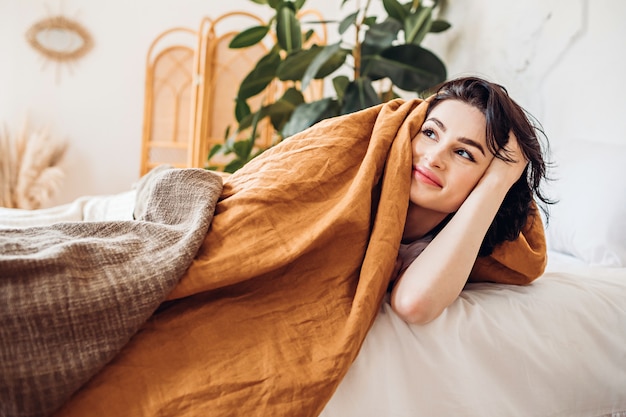 Sonriente mujer acostada en la cama