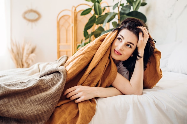 Sonriente mujer acostada en la cama