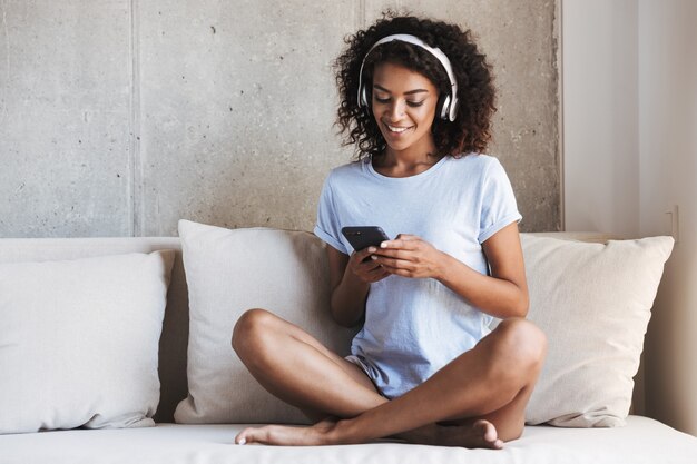 Sonriente mujer africana en auriculares