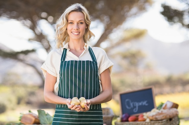 Sonriente mujer agricultor con patatas