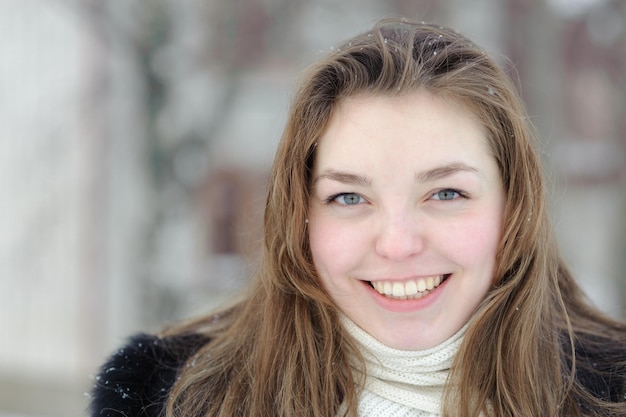 Foto sonriente mujer bonita contra la naturaleza de invierno