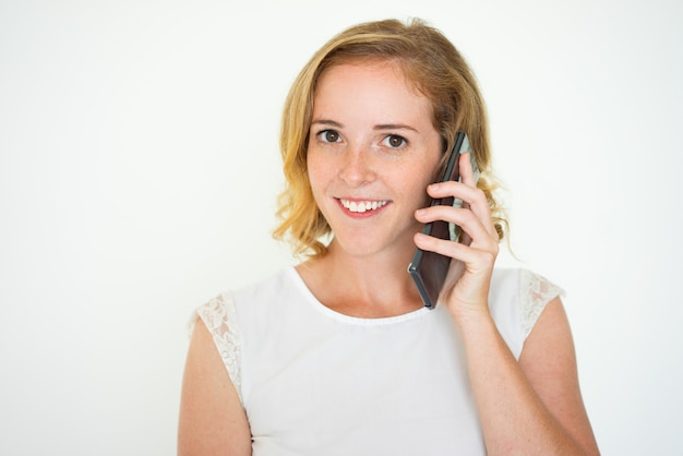 Sonriente mujer bonita llamando a un teléfono inteligente